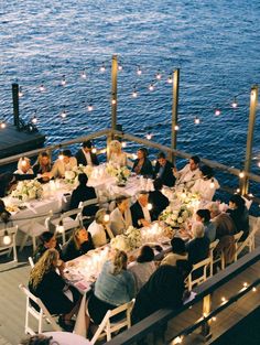 a group of people sitting at tables on top of a pier