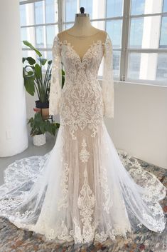 a wedding dress on display in front of a window