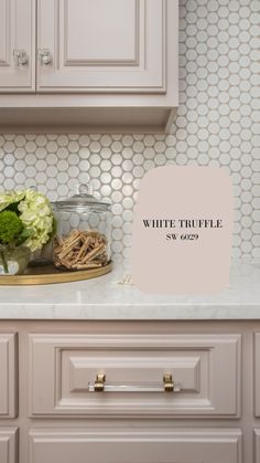 a white kitchen counter with some flowers on it and a sign that says white truffle