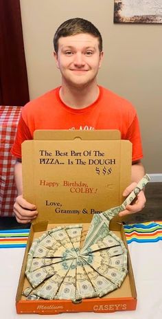 a man holding up a pizza box with money in it's front and the words happy birthday, colly written on it