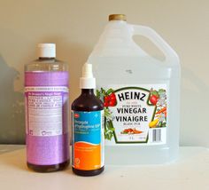 two bottles of vinegar and a bottle of sunscreen on a table