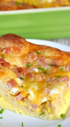 a slice of ham and cheese casserole on a white plate with green onions