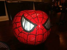 a spiderman pumpkin sitting on top of a wooden table