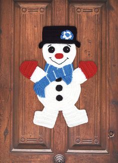 a crocheted snowman is hanging on the front door