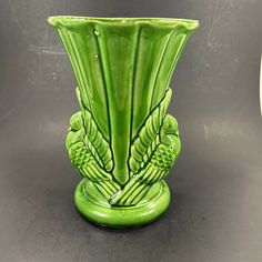 a green vase sitting on top of a table