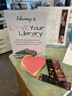 the library's love your library sign is next to some books and other items