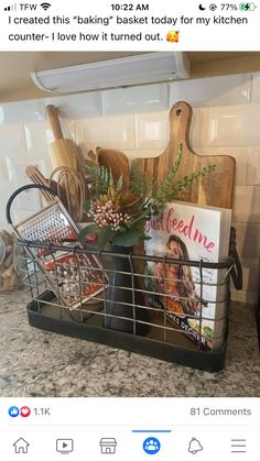 a metal basket filled with cooking utensils and cookbooks on top of a kitchen counter