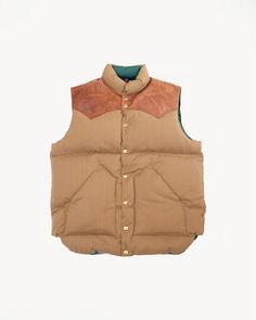 Warehouse & Co. We were instantly enamored by this vest. This is a special collaboration between Japan's Rocky Mountain Featherbed and Warehouse. If this vest reads familiar, that is because it's an iconic silhouette from the 70s. This variation is Warehouse's special colorway. It instantly transports you to a snowy mountaintop. The leather yoke is horsehide vs cowhide this round too..again Warehouse's doing. You're looking at a 90/10 down fill on this which is the highest grade, best ... Cotton Vest With Padded Collar And Sleeveless Design, Classic Sleeveless Beige Outerwear, Fitted Sleeveless Outerwear With Padded Collar, Classic Beige Sleeveless Outerwear, Cotton Sleeveless Vest With Padded Collar, Fitted Beige Winter Vest, Sleeveless Cotton Vest With Padded Collar, Brown Rugged Vest For Winter, Brown Rugged Winter Vest