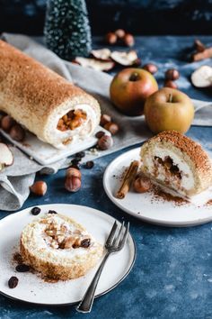 two white plates topped with desserts on top of a blue table covered in nuts