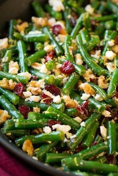 green beans with cranberries and walnuts in a skillet on a table