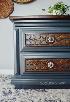 an old dresser has been painted gray with wood carvings on the top and bottom drawers