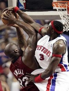 two men playing basketball in front of a crowd