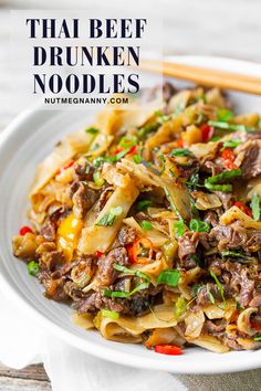 thai beef and noodle stir fry on a white plate with chopsticks in the background