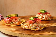 three appetizers are on a wooden platter