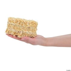 a hand holding a piece of straw on it's palm against a white background