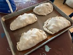 three uncooked dumplings sitting on top of a pan