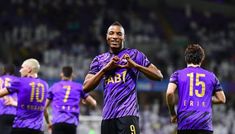 soccer players in purple uniforms applauding each other