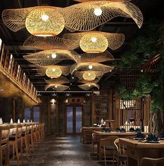 a restaurant with wooden tables, chairs and lights hanging from the ceiling above them is lit up by dim lighting