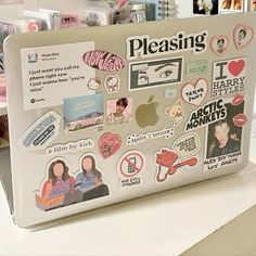 a laptop with stickers on it sitting on a table