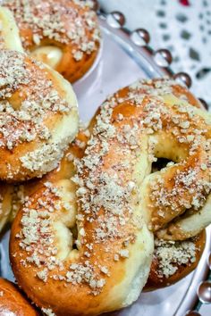 several donuts covered in powdered sugar sit on a silver platter with beads