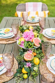 the table is set with grapefruits, lemons and flowers