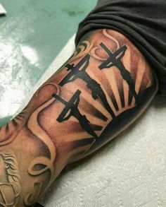 a man with a cross tattoo on his arm