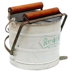 an old white bucket with some wooden handles