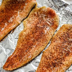 two fish fillets sitting on top of tin foil