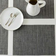 a white plate with silverware on it next to a cup and saucer