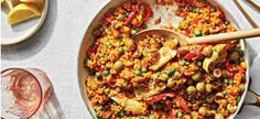 a large pan filled with food on top of a table next to utensils