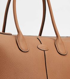 Central ribbing and tubular handles characterize this elegant shopping bag with Tod's logo stamped on the front. Featuring an internal pouch, it is crafted in soft calfskin leather. To accompany with class and femininity your everyday outfits. Designer Travel Bags With Round Handle, Luxury Tan Everyday Bag, Cognac Calf Leather Bag With Handles, Rectangular Tan Business Bags, Tan Rectangular Business Bags, Cognac Leather Bag With Round Handle, Business Brown Bags With Handles, Designer Rectangular Bag With Rolled Handles, Classic Calf Leather Shoulder Bag With Handles