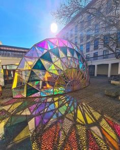 the sun shines brightly on an art installation in front of a building