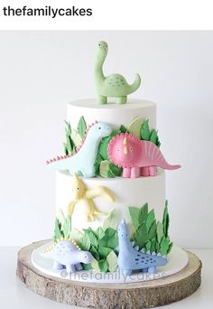 a three tiered cake decorated with fondant dinosaurs