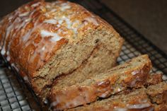 a loaf of glazed banana bread sitting on top of a cooling rack with icing