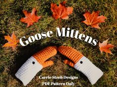 an orange and white knitted mitten laying on top of grass next to leaves