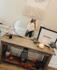 a woman taking a selfie in front of a mirror on a table with candles