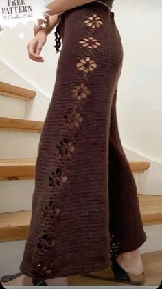 a woman is standing on the stairs wearing a brown knitted skirt with cut outs