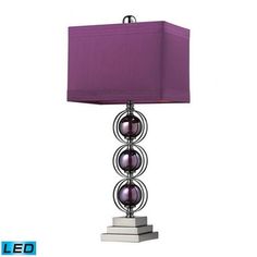 a table lamp with a purple shade on the top and silver base, sitting next to a