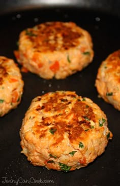 four crab cakes cooking in a pan on top of a stove burner with the rest of the patties being cooked