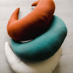 three pillows stacked on top of each other in the shape of an animal's tail