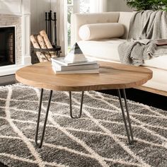 a living room with a white couch, coffee table and rug on the floor in front of a fireplace