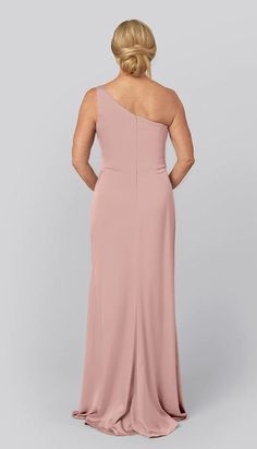 a woman in a long pink dress with one shoulder and open back, looking down at the