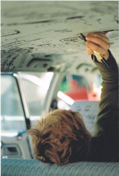 a person writing on a piece of paper in the back seat of a car,