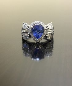 DeKara Designs Collection Beautiful Modern/Art Deco Ceylon Blue Sapphire and Diamond Ring Metal- 18K White Gold, 750. Stones- 1 Pear Shape Ceylon Blue Sapphire 2.25 Carats, 2 Tapered Baguette Diamonds F-G color VS1 clarity 0.60 Carats, 4 Pear Shape Diamonds F-H Color VS2 Clarity 1.05 Carats, 20 Round Diamonds G Color VS2 Clarity 0.25 Carats. 1.90 Total Carats of Diamonds. Art Deco Inspired 18K White Gold Ceylon Blue Sapphire Diamond Engagement Ring. There is a three prong set pear shape pear sha Sapphire Diamond Engagement Ring, Ceylon Sapphire Ring, Sapphire Wedding Ring, Art Deco Sapphire Ring, Diamond Sapphire Engagement Ring, Sapphire Diamond Engagement, Ceylon Blue Sapphire, Sapphire Wedding Rings, Art Deco Wedding Rings