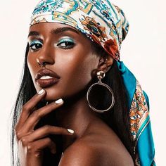 a woman with blue eyeshades and a bandana on her head is posing for the camera