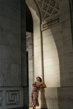 a woman leaning against a wall in an archway