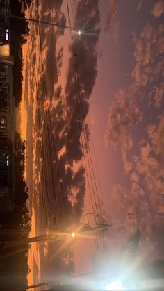 the sun shines brightly in front of dark clouds and power lines on a city street