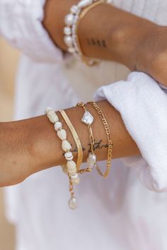 "Flanked with natural white puka shells and pikake flowers, this unique shell bracelet evokes visions of Hawaii's white sands and soothing shores. Stack this gold bracelet with other beaded beauties and you'll be ready for your tropical escape. ✦ DETAILS ✦ ✧ Name: Me'e (MAY aye) - Heroine. ✧ Adjustable from 6.5\"-8\". ✧ 6-7mm White Puka Shells. ✧ Carved Resin Pikake Flowers. ✧ 14kt Gold Filled with lobster clasp. ✧ All Ke Aloha Jewelry pieces come packaged thoughtfully, beautifully, and ready fo White Shell Dainty Jewelry, White Shell Bracelets As A Gift, White Shell Bracelets Perfect For Gifts, White Bohemian Jewelry With Oyster Bracelet, White Shell Oyster Bracelet, White Oyster Bracelet Jewelry For The Beach, White Bangle Bracelets For Vacation, White Bangle Jewelry For Vacation, Pearl Bracelet Jewelry For Beach