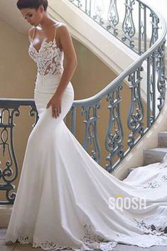 a woman in a wedding dress is standing on the stairs with her hand on her hip