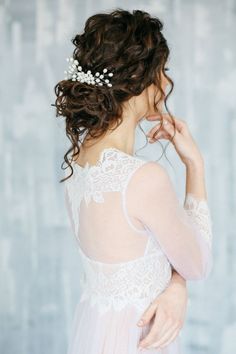 a woman wearing a white dress and a hair comb